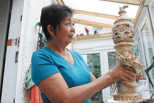 British ceramics artist Jessie Lee with her first work, a candlestick she made 40 years ago.(Photo provided to China Daily)