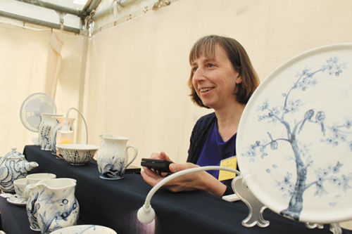 Mia Sarosi, a ceramics artist based in Oxfordshire, with her blue and white porcelain works at an exhibition. (Photo provided to China Daily)